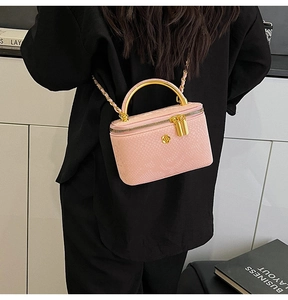 Detailed close-up of pink snake skin texture bag with gold handle and chain strap
