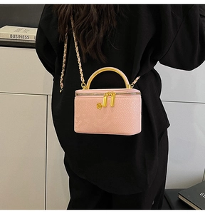 Detailed close-up of pink snake skin texture on chain vanity bag with golden flower charm