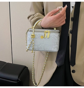Detail of silver snake skin texture mini bag with gold chain strap and camellia ornament