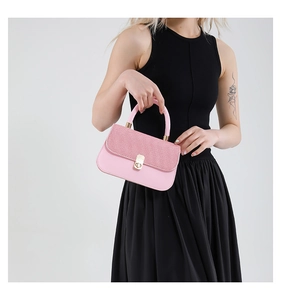 Detail of pink crossbody bag with glitter flap and gold rotating metal clasp closure