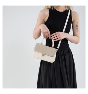 Detail of cream leather handbag featuring woven flap design and gold twist lock closure