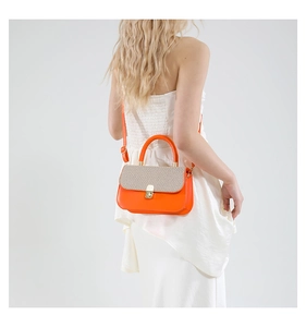 Rear view of a model wearing the orange contrast crossbody bag with woven flap detail