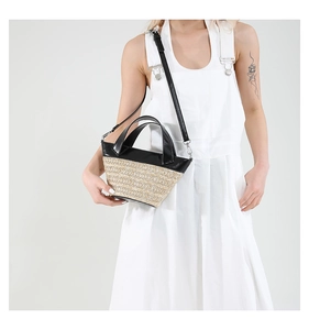 Close-up of the woven texture and contrast black leather trim on a stylish bucket bag