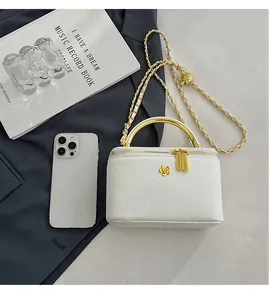 Mini white snake-textured makeup box bag compared with a phone for size scale