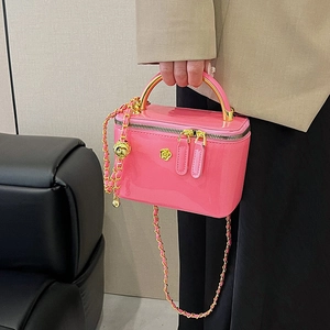 Pink glossy patent leather crossbody bag with chain strap and gold floral logo detail