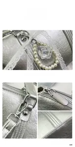 Detail of silver metallic Boston bag featuring white lace ribbons and bead charms