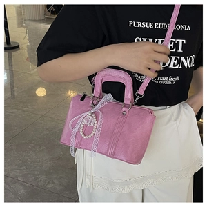 Pink Boston bag with lace pearl charm shown as a crossbody bag on a model