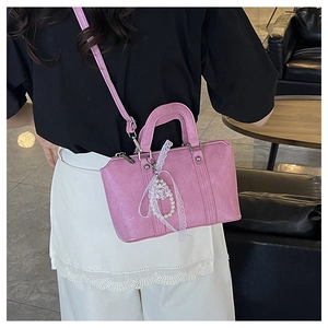 Close-up of pink bow pillow bag with pearl lace pendant and pleated leather detail