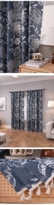 Détail du tissu de rideau floral bleu avec franges à pompons blancs et texture