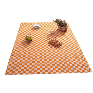 Classic orange checkered outdoor picnic mat with rustic woven texture and gourmet accessories