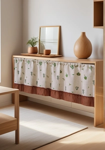 Detailed view of linen cabinet curtain with green cactus pattern and brown ruffle trim