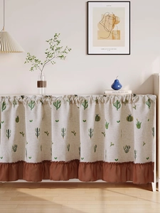 Detail of linen cupboard curtain with green cactus prints and dark brown ruffled edge