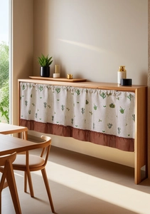 Detail of linen cabinet curtain with cactus print and brown ruffled edge in soft light