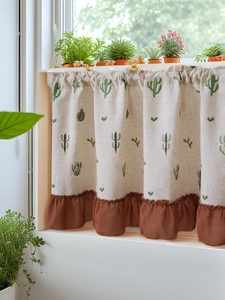 Close-up of pastoral linen cafe curtain featuring cactus embroidery and brown ruffled trim