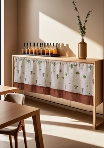 Detail of linen cabinet curtain with cactus print and brown ruffled edge trim