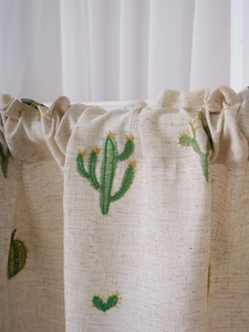 Detail of linen fabric cafe curtain with cactus embroidery and pleated top design