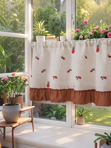 Detail of linen cafe curtain featuring red fruit embroidery and caramel ruffled edges