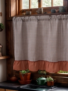 Close-up of brown gingham cafe curtain with terracotta ruffled hem in a rustic kitchen
