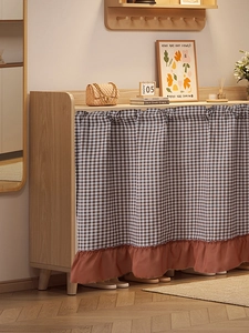 Detailed view of brown checkered cabinet curtain with reddish pleated ruffle trim