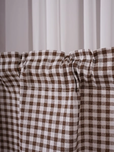Detail of brown gingham cabinet curtain fabric showing textured cotton linen weave