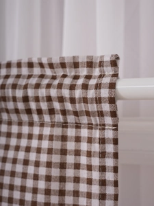 Close-up of brown gingham cafe curtain featuring cotton linen texture and rod pocket design