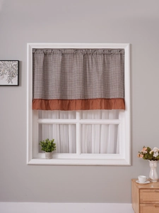 Detail of checkered cafe curtain with rust red ruffle trim for American style cabinets
