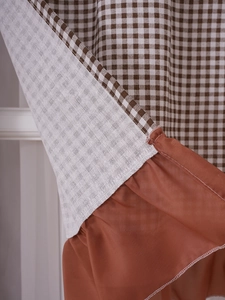 Detail of American style brown gingham cabinet curtain with elegant ruffle trim