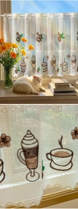 Detail of white lace cafe curtain featuring coffee bean and cup embroidery for kitchen