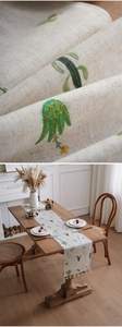 Detail of linen table runner with cactus embroidery and elegant white tassels