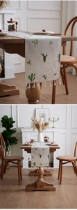 Close-up of rustic linen table runner with green cactus embroidery and white tassels