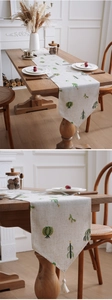 Macro shot of embroidered cactus patterns and handmade tassels on linen table runner
