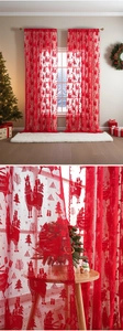 Detail of red Christmas lace curtain with embroidered reindeer, trees and festive patterns