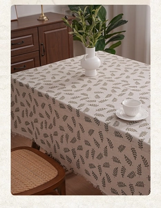 Detailed close-up of linen blend tablecloth with vintage leaf print and fringe edges