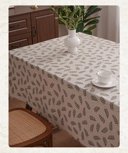 Close-up of fresh leaf pattern on polyester tablecloth with fringe edge detail