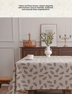 Close-up of cotton linen tablecloth featuring small black leaf patterns on beige fabric