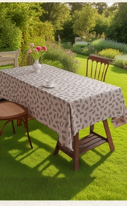 Linen rectangle tablecloth with fern leaf pattern and fringe detail in sunlit garden