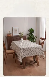 Detailed close-up of cotton linen tablecloth with leaf patterns and handmade fringe edges