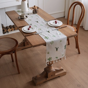 Linen table runner with green cactus print and white tassels for rustic dining decor