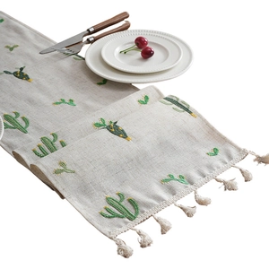 Linen table runner with green cactus embroidery and decorative fringe for home decor