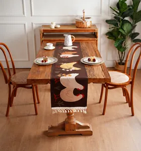 Gros plan du chemin de table marron foncé imperméable avec imprimés coqs et franges