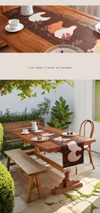 Détail d'un chemin de table imperméable avec imprimé poulet et pompons blancs