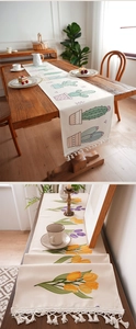 Detail van tafellopers met bloemen- en cactusprint en decoratieve witte kwastjes