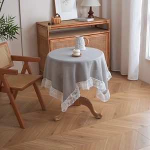 Dettaglio della tovaglia in lino grigio con elegante bordo ricamato in pizzo bianco alto