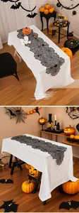 Detail of black lace spiderweb table runner for Halloween party fireplace decoration