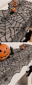 Detail of black lace spider web table runner with intricate mesh patterns for Halloween decor