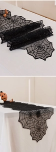 Detail of black lace spider web table runner for Halloween party fireplace decoration