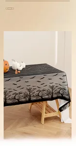 Close-up of black Halloween lace tablecloth featuring bats and withered tree patterns