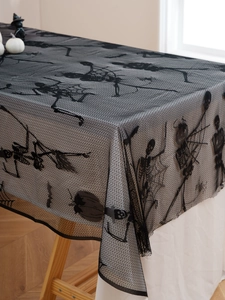 Detail of Halloween black lace tablecloth featuring skull, spider web and bat patterns