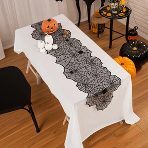 Black lace spider web table runner for Halloween home decor with pumpkin accents