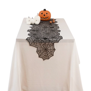 Black lace spider web table runner for Halloween party decor over white tablecloth